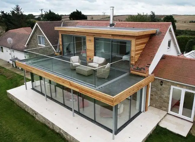 Modern steel parapet wall design featuring glass panels, concealed bracing, and contemporary rooftop safety systems for residential terraces.